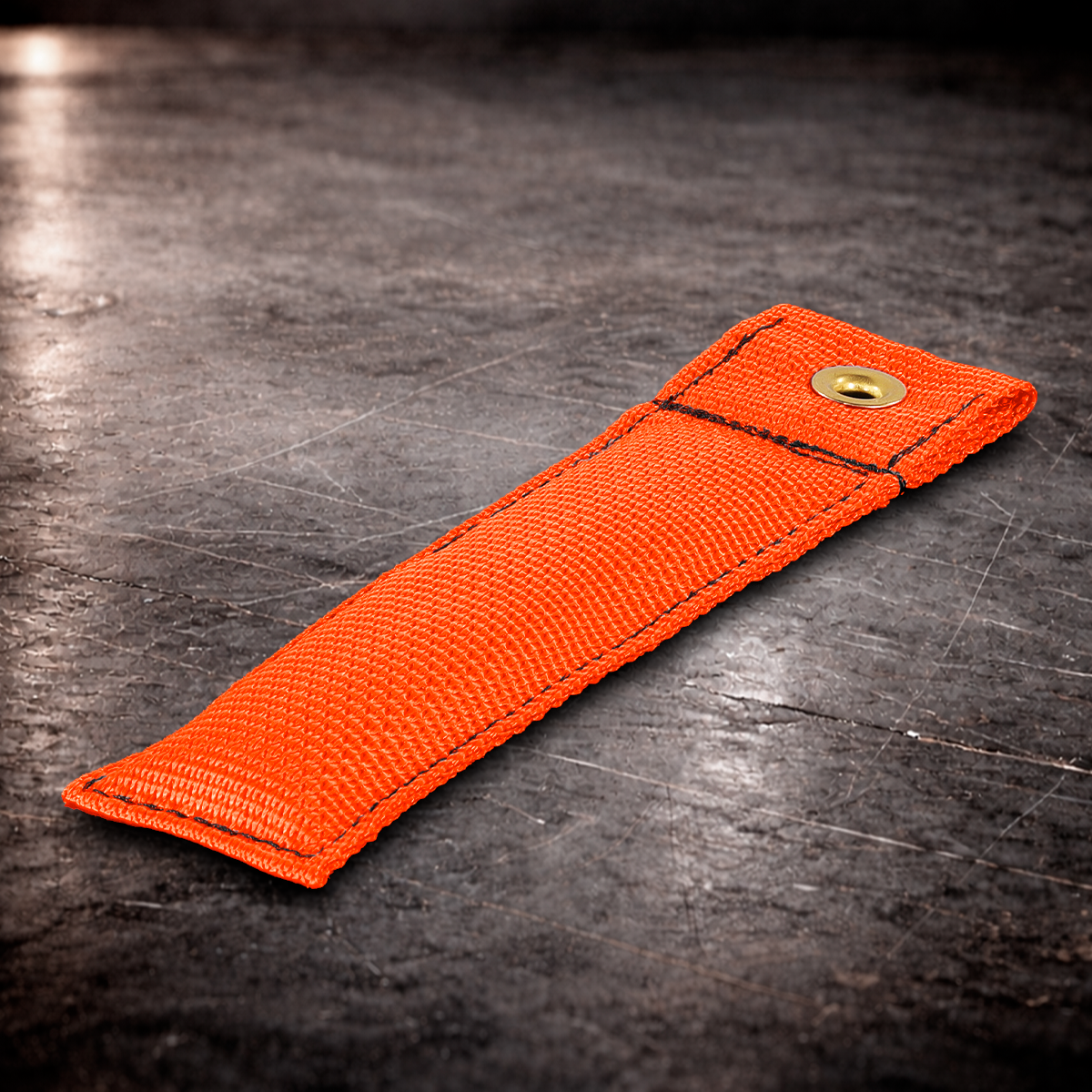 6 inch orange marker with grommet on industrial surface orange fabric marker close up stitching detail 6 inch grip marker with brass grommet orange
orange set marker on dark warehouse background film production marker orange with grommet