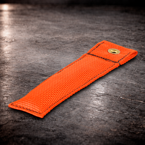 6 inch orange marker with grommet on industrial surface orange fabric marker close up stitching detail 6 inch grip marker with brass grommet orange
orange set marker on dark warehouse background film production marker orange with grommet